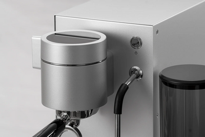 Close-up of a WPM PRIMUS silver coffee machine with a silver spout and black handle on a white background